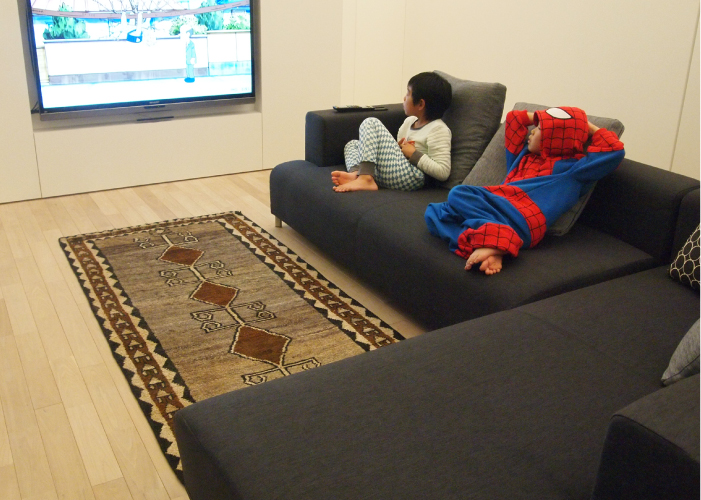 ソファの上でテレビを見る子供たち