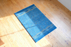 ブルーグラデーションに小さな文様が描かれたギャッベ